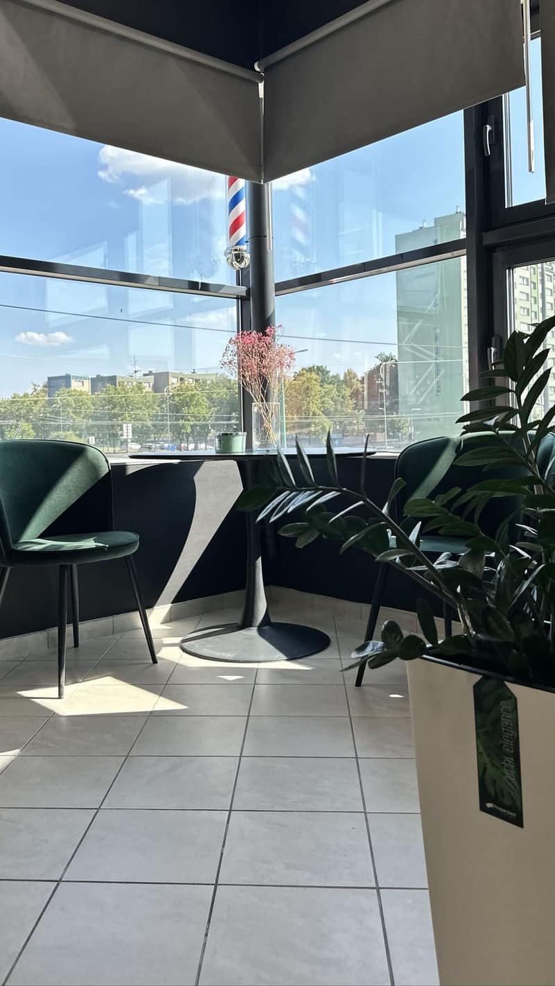 Jasna strefa oczekiwania ALIA Barber w Tychach z zielonymi fotelami przy oknie
