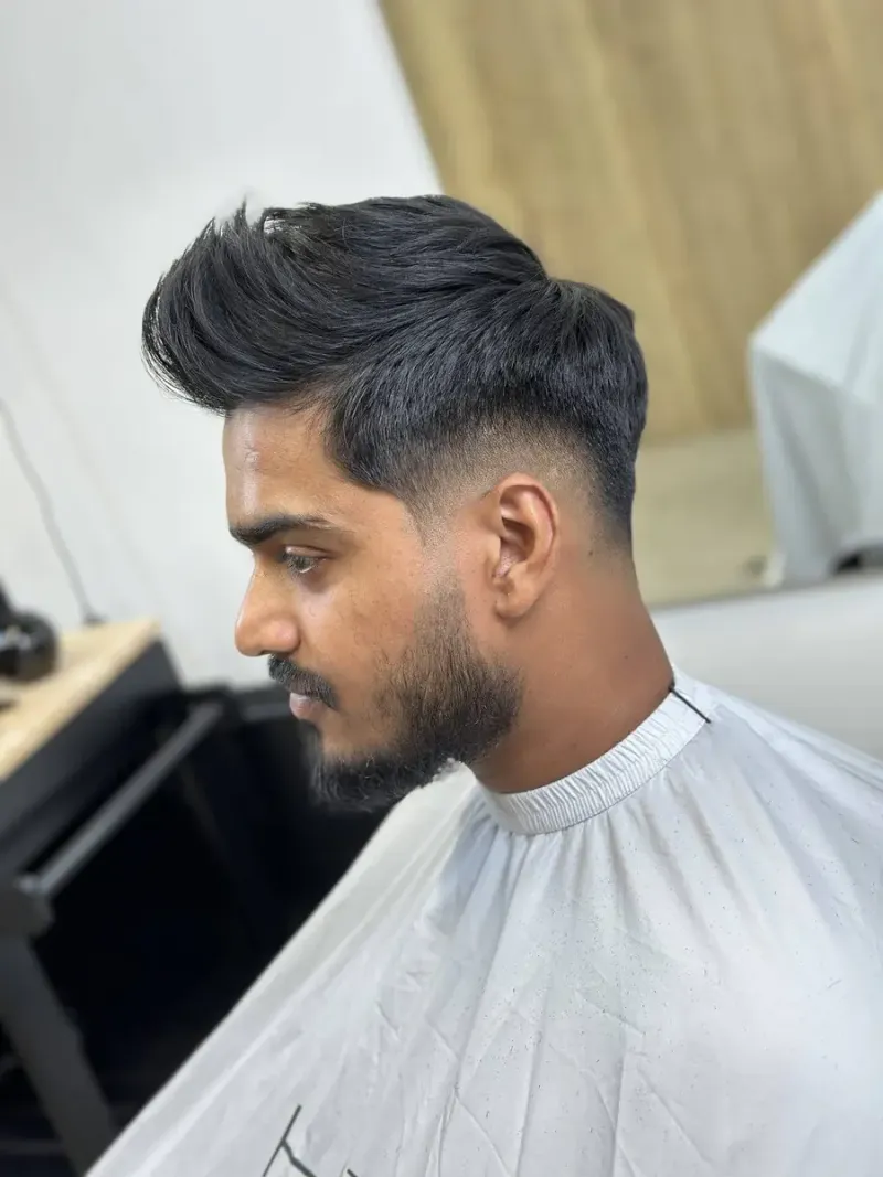 Teksturyzowany quiff z dużą objętością na górze i łagodnym taper fade po bokach